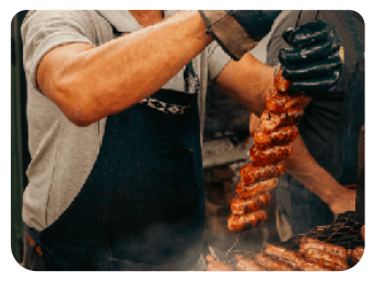 Un asador preparando carne a la parrilla